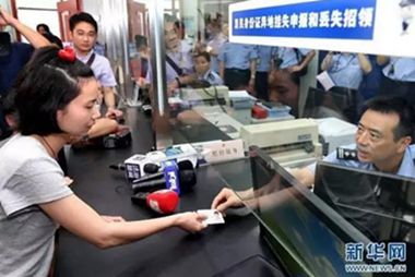 来沪人员领取异地办理的身份证。(图片来源:新华社)